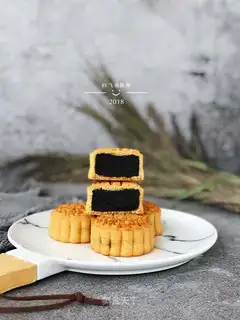 A broad black sesame moon cake
