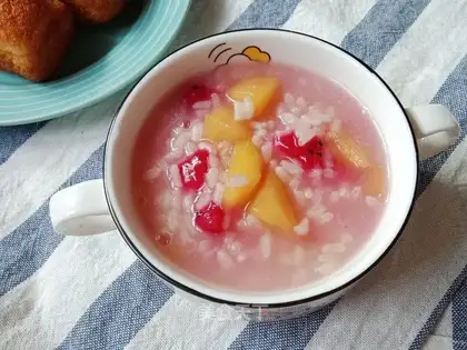 The baby feeds fruit porridge