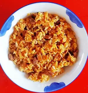 The lamb's hand grabs rice