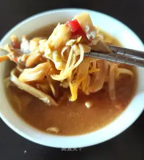 Soup with a yellow flower and tomatoes